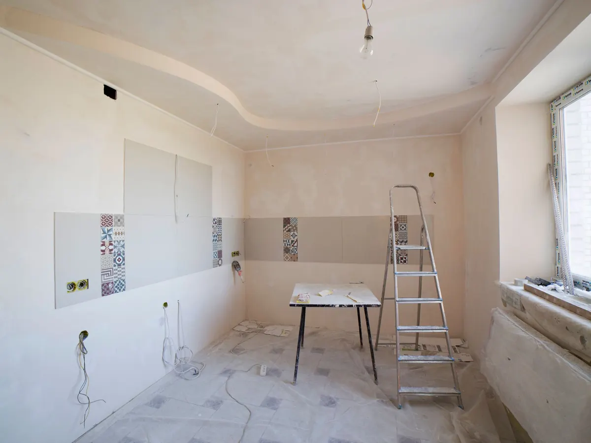 Una stanza durante i lavori con scala e piastrelle