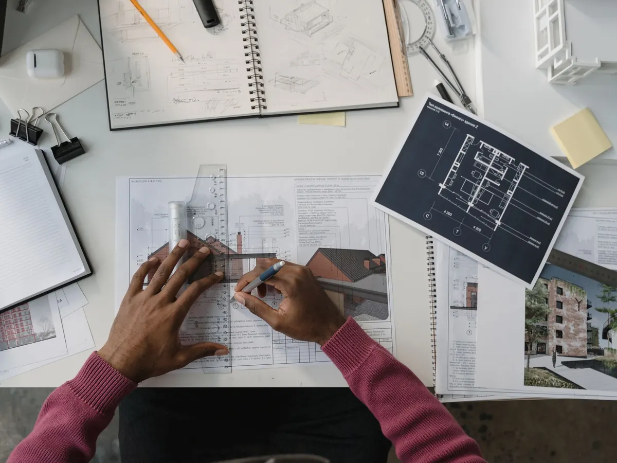 Un tecnico al tavolo con disegni e progetti